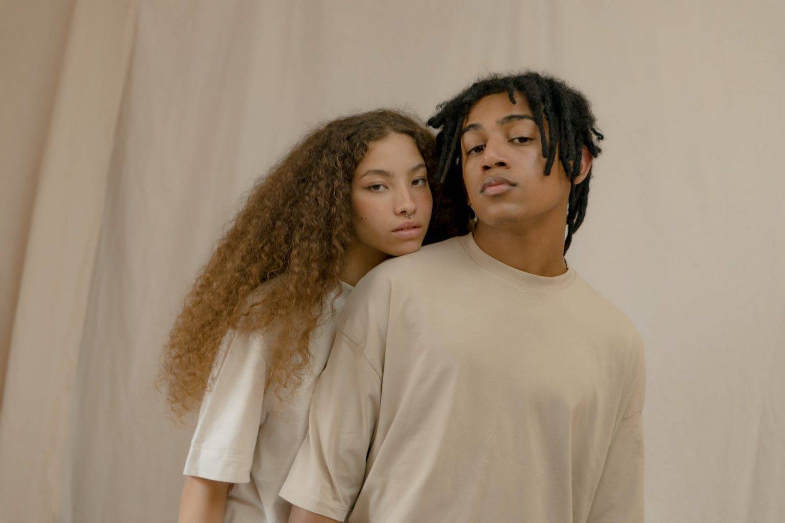 man and woman wearing crew neck t shirts standing close together